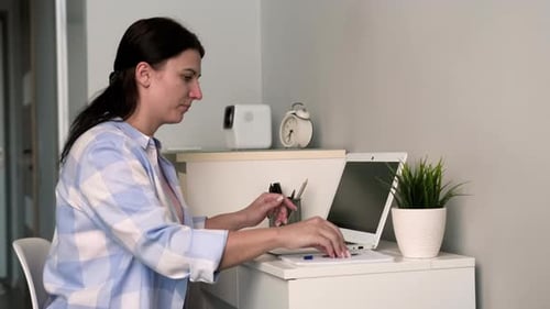 Woman Typing on Laptop at Desk