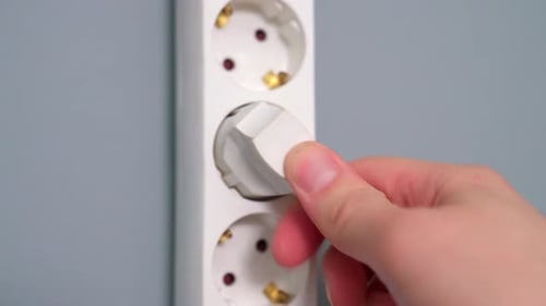 Plugging White Cord Into Electrical Outlet