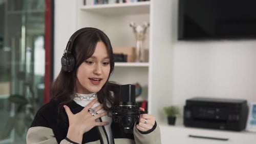 La femme charismatique s'assoit et communique par vidéoconférence. Elle tient un micro professionnel