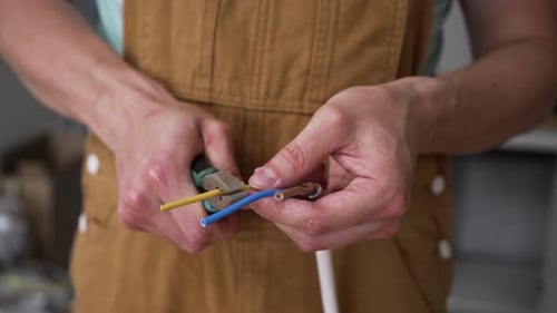 Worker Stripping Electrical Wires with Pliers Close Up