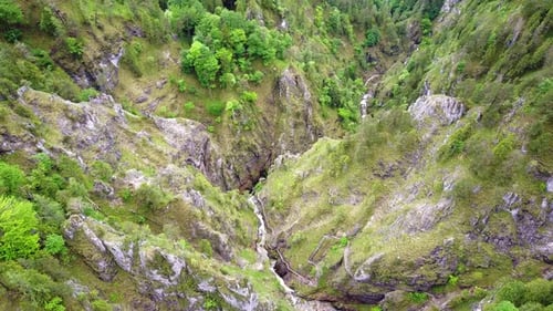 A drone shot of a river that runs through the mountains with waterfalls