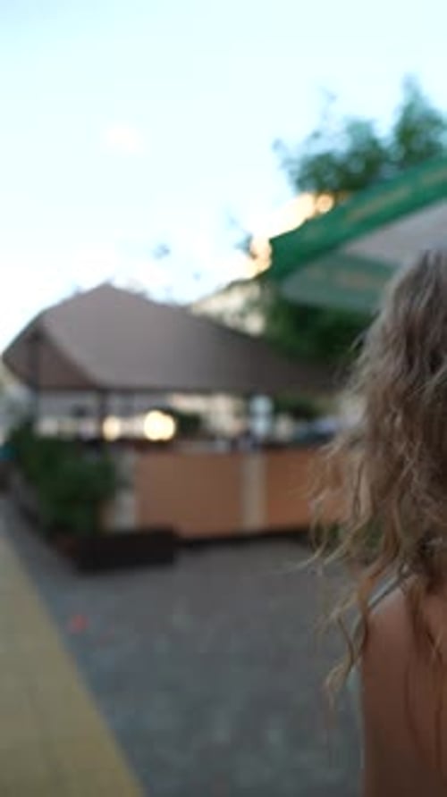 Young Woman Walking Along City Sidewalk
