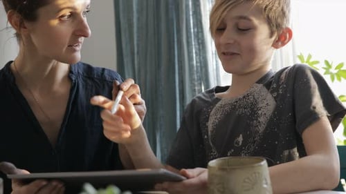 Woman and Boy Interact with a Tablet Device
