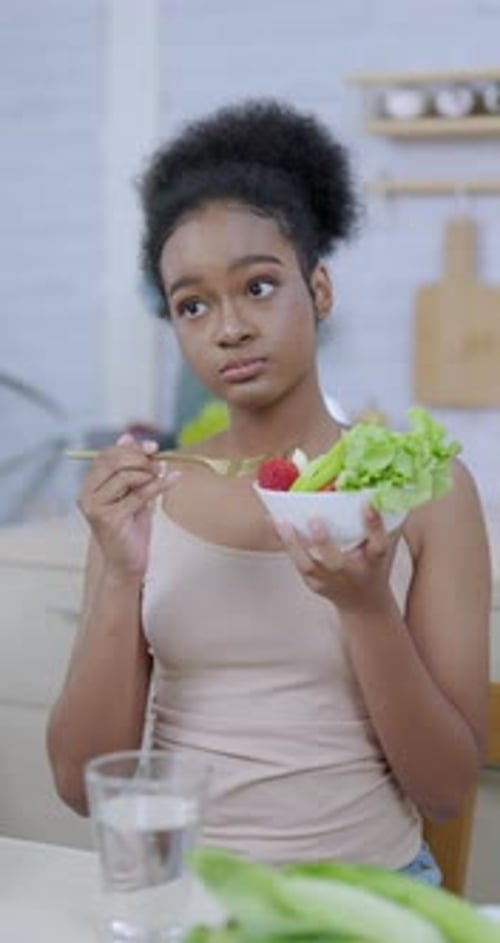 Healthy young woman eating a fresh salad