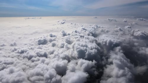 Aerial View From Airplane Window at High Altitude of Earth Covered with Puffy Cumulus Clouds Forming