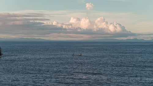 Still drone clip of fisherman on the ocean.