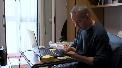 Man Working on Laptop at Home on Desk