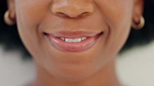 Closeup of smiling dentist showing white teeth with orthodontic invisible braces