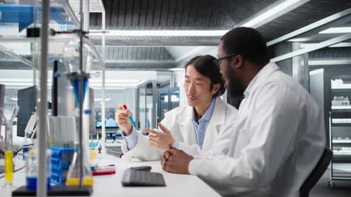 Ingenieros de laboratorio multirraciales inspeccionan líquidos en tubos de ensayo