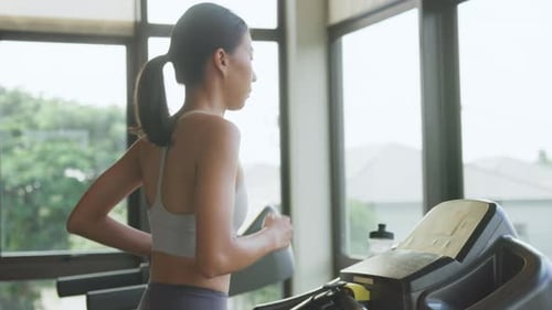 Asiatische Frauen tragen Sport-BH und Smartwatch verbinden sich mit laufender Techno-Maschine und starten Morgenroutine