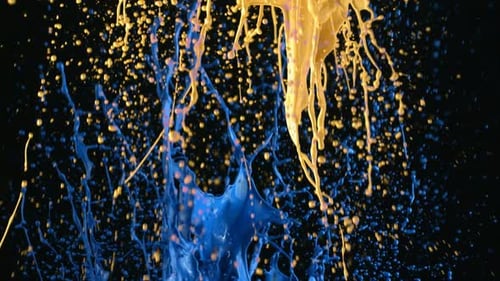 Yellow and Blue Paint Splashes Against Black Background