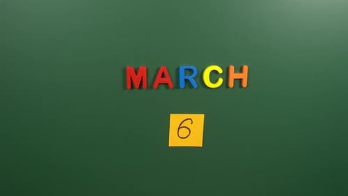 Hand sticking a sticker 6 March calendar day on school board. 6 date of March. Sixth day March