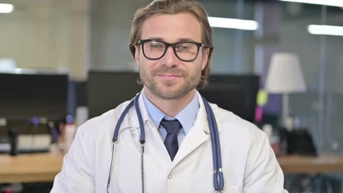 Handsome Doctor Smiles In Medical Coat and Glasses