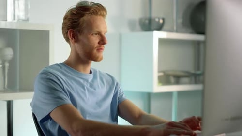 Man Typing at Desktop Computer in Bright Home Office