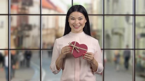 Smiling Woman Holding Heart Shaped Gift Box