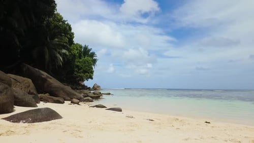 Felsige Küste mit klarem Flachwasser und grünem Laub Seychellen Mahe