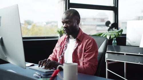 Young Adult Types on Computer in Urban Office