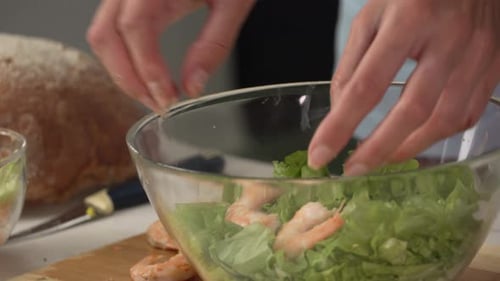Adding Shrimp to Salad in Kitchen
