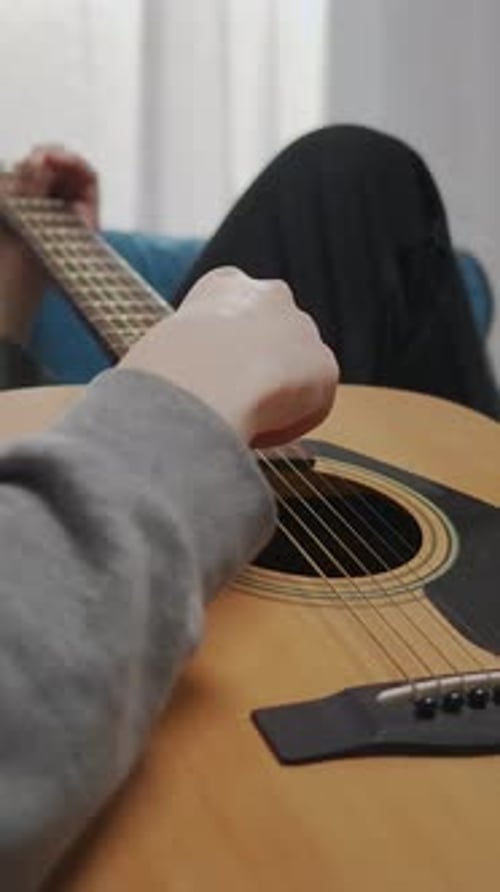 Close Up of Guitar Playing at Home