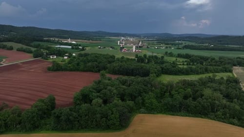 Luftüberflug über gelbe und rote bewirtschaftete Farmfelder auf dem amerikanischen Land. Gehöfte in
der Ferne