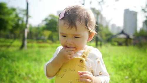 Multi-racial Asian baby girl toddler playing at a city park is adorable - slow motion