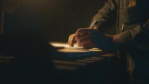 A male engineer works with drawings lying on the table, using a pencil