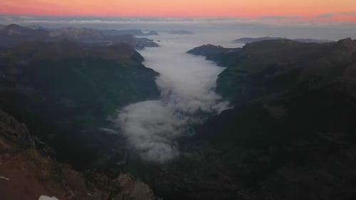 Aerial shot panning up, revealing the majestic and dramatic view over the valley from the top of the