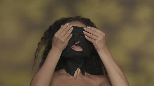 Woman Applies and Removes a Black Sheet Mask