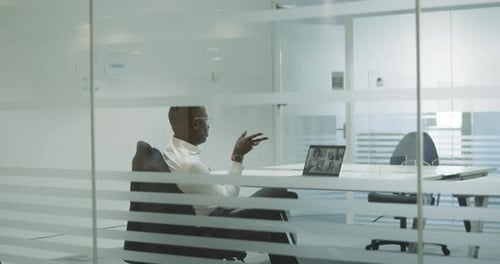 Professional Man Attends Virtual Meeting in Modern Office