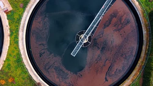 Water recycling facility with large round reservoir. Waste water treatment plant from aerial view.