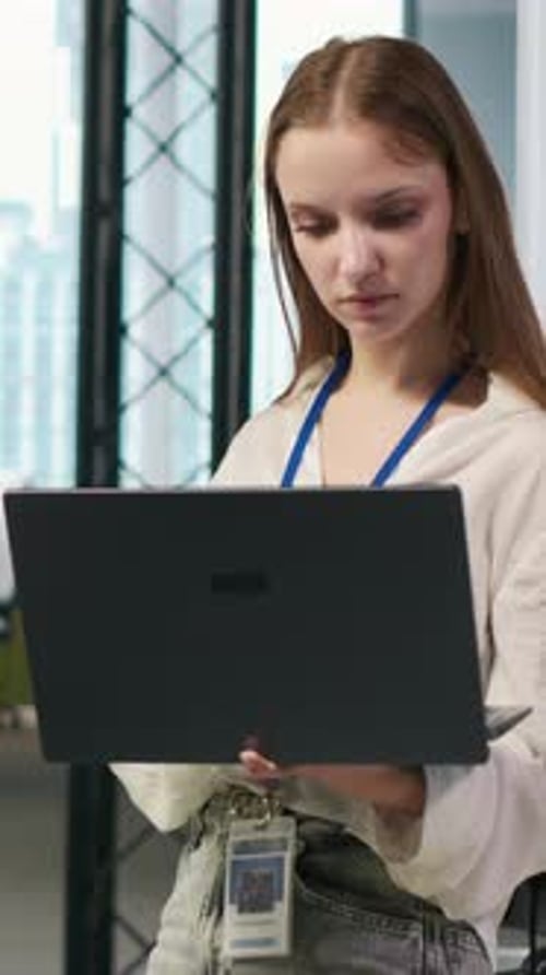 Vertical Video Portrait of Young Smiling Female Programmer in Office Automating with AI