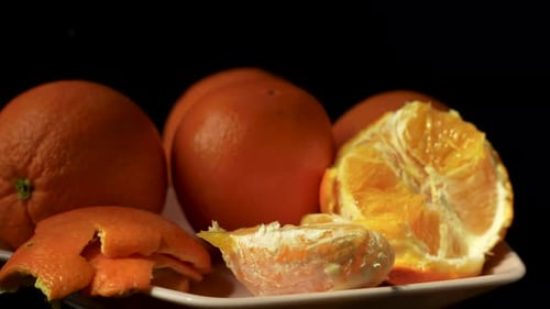 Rotating peeled orange half with bright juicy pulp and visible fibers.