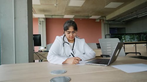 Tired Indian Doctor Working Late After a Long Day at the Office