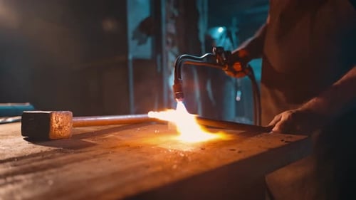 View of a Worker Holding a Gas Cutter for Heating Metal