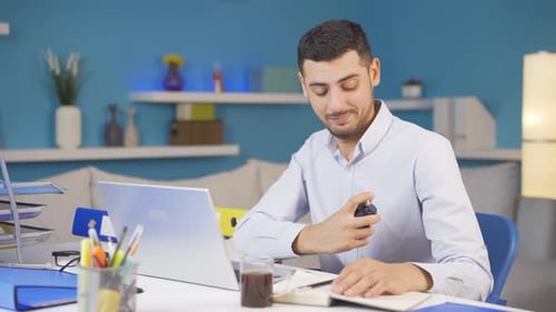 Home office worker sprays perfume on man.