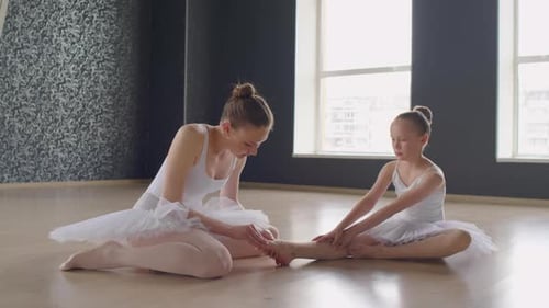 Female Trainer Stretching Girls Toes at Ballet Class