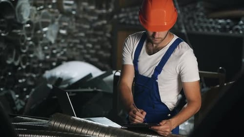 Man in uniform works on the production. Industrial modern technology