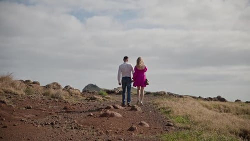 Couple Walking Away on Dirt Road Holding Hands