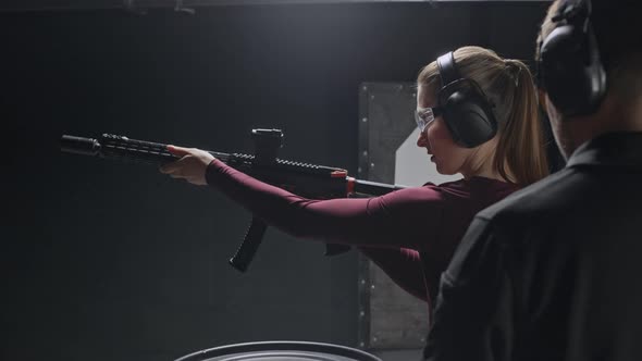 Woman Reloading and Aiming Rifle Having Practice with Male Instructor ...