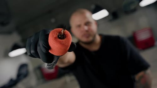 Tattoo studio interior - male tattoo artist showing a sterile tattoo machine