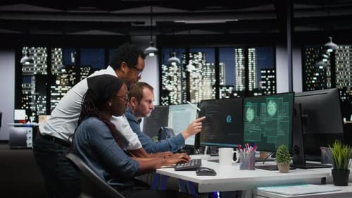 Team of Programmers in Office Working Together to Block Hacker Intrusion