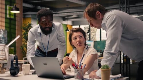 Team Discussing Project on Laptop in Modern Office
