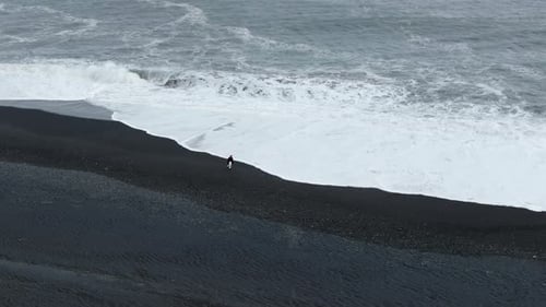 Experience the Stunning Beauty of Aerial Views of a Dramatic Black Sand Beach in Iceland with Waves
