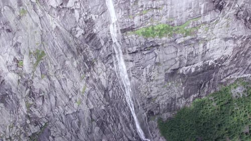 aerial view of norwegian fjords and waterfall through clouds