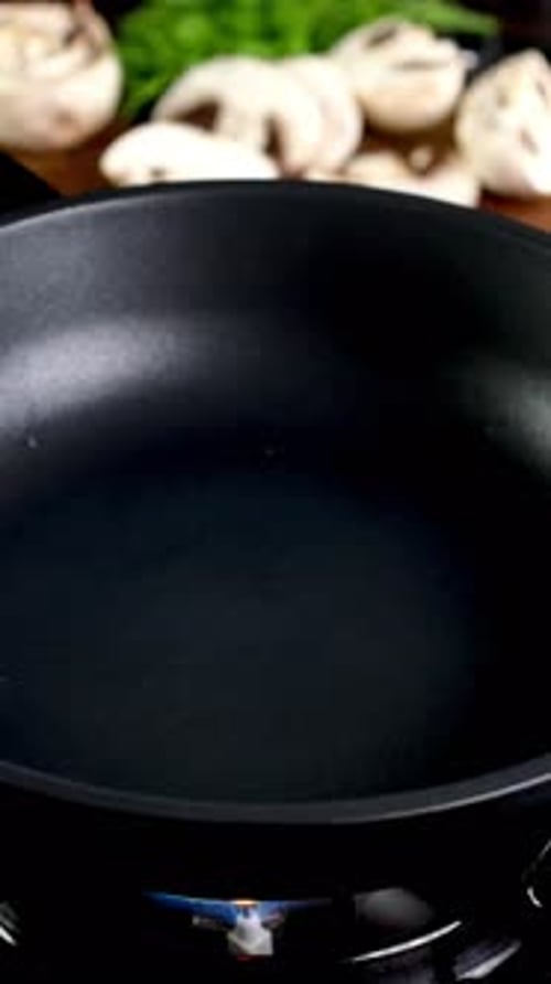 Chef Adds Aromatic Sunflower Oil to Frying Pan on Gas Stove on Right Amount