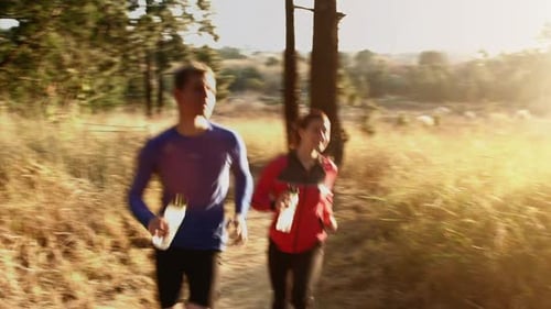 Young couple running on mountain trail at sunrise in beautiful rural landscape