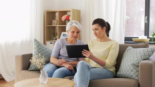Woman and senior adult looking at a tablet