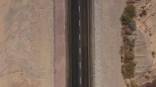 Cars driving on a Desert road surrounded by dry land, Aerial view