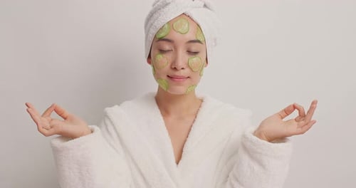 Woman Meditating with Cucumber Slices on Face