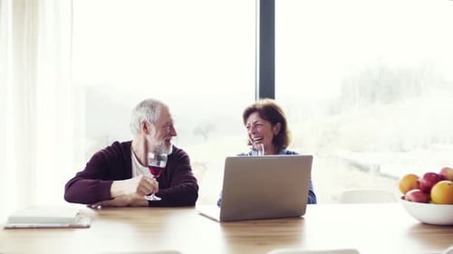 Senior Couple Video Chatting and Celebrating with Wine
